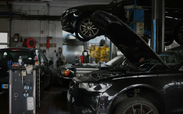 Audi negru cu capota ridicată într-un service auto european